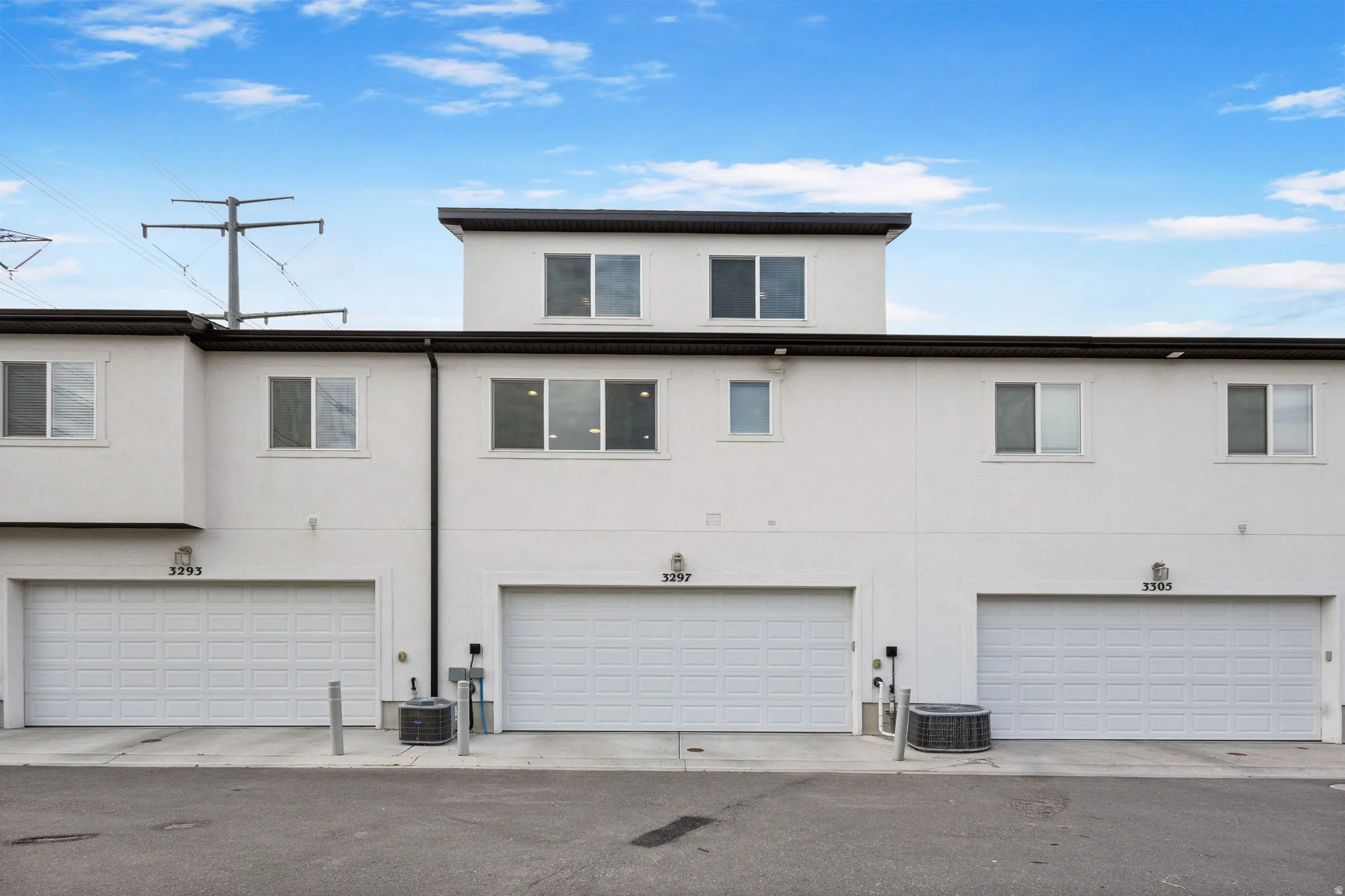 Contemporary stucco exterior with multiple garage bays