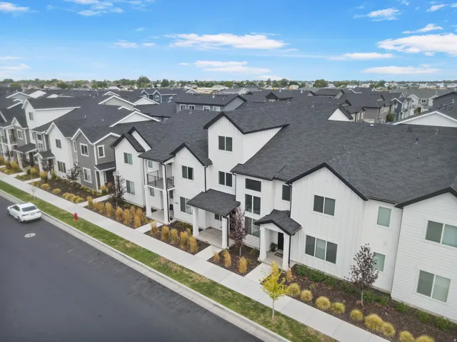 Contemporary multi-story residences featuring vertical white siding, dark trim, and dark shingle roofs