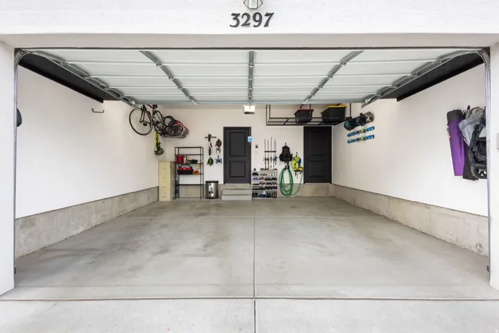 Two-car garage featuring a concrete floor, white walls, and two internal access doors