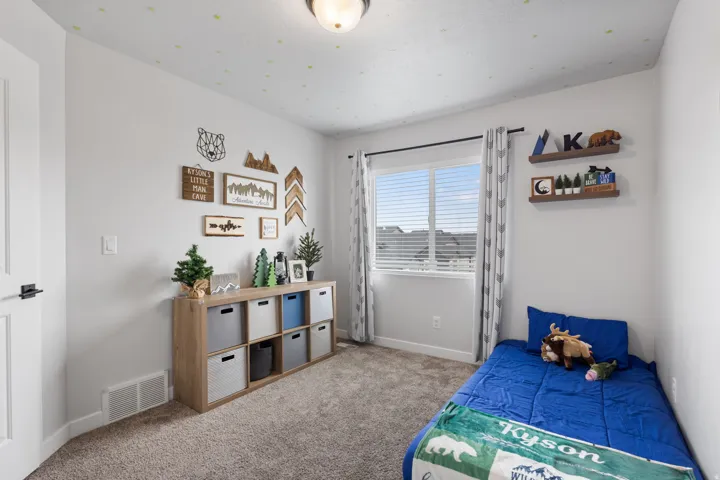 Carpeted room featuring a white door with matte black hardware, a multi-pane window with blinds, and two wall-mounted floating shelves