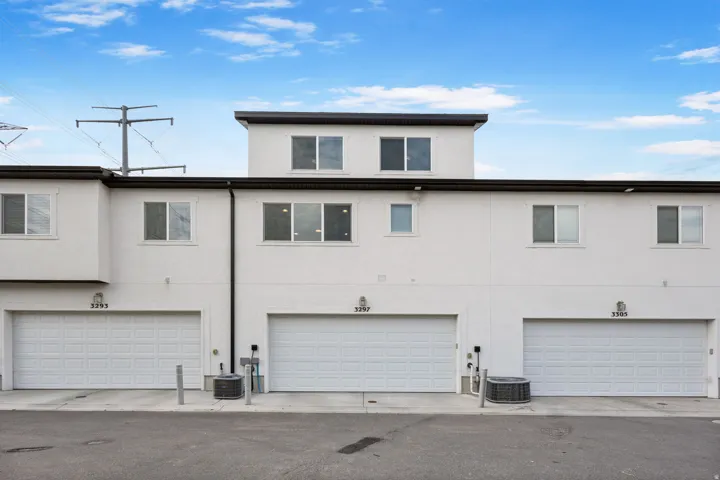 Contemporary stucco exterior with multiple garage bays
