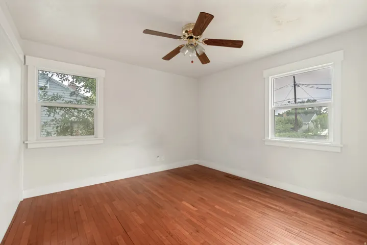 Hardwood flooring throughout, complemented by a ceiling fan with integrated lighting