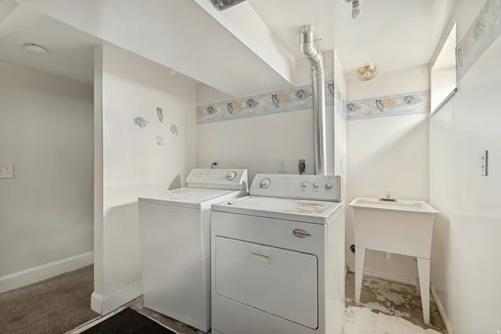 Dedicated laundry area featuring a utility sink and essential appliance hookups