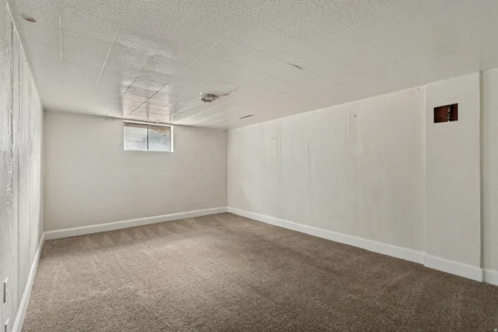 Spacious basement room featuring neutral wall finishes, carpeted flooring, and recessed ceiling lighting