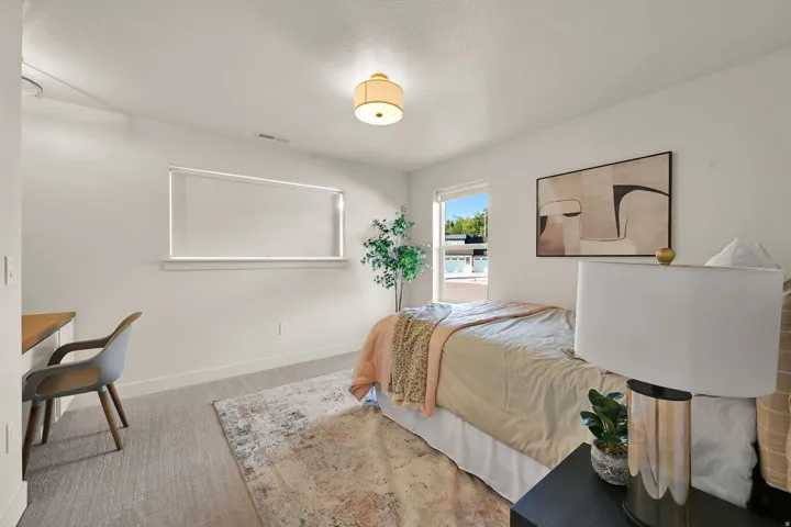 Bright room featuring neutral-toned carpet, white walls, and a contemporary ceiling fixture