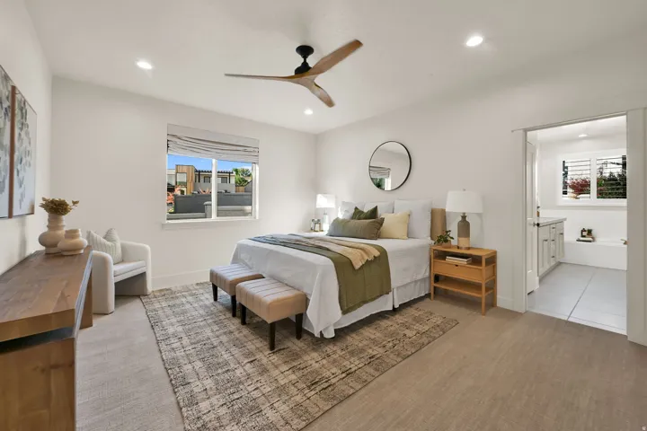 Spacious Primary bedroom featuring light-colored carpeting, a contemporary ceiling fan, and recessed lighting