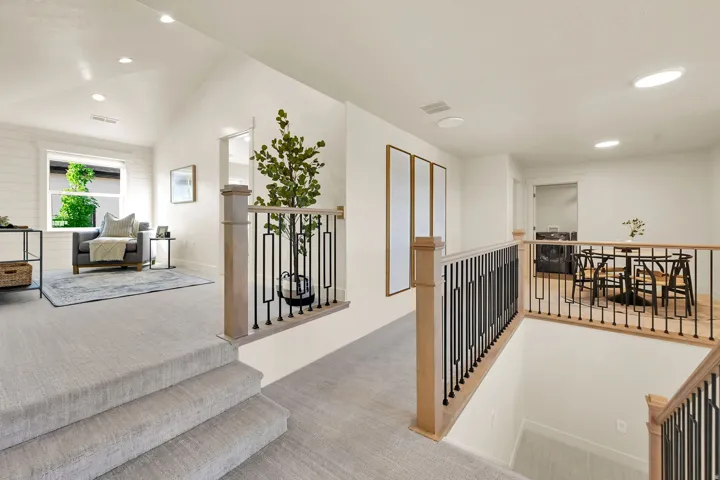 Carpeted stairs leading to a spacious loft area with shiplap wall accents and recessed lighting