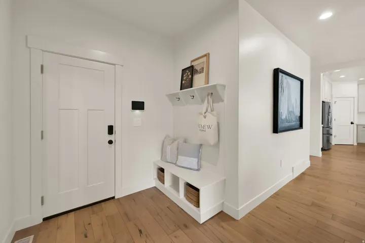 Entryway featuring wood-finish flooring and a craftsman-style door with a smart lock