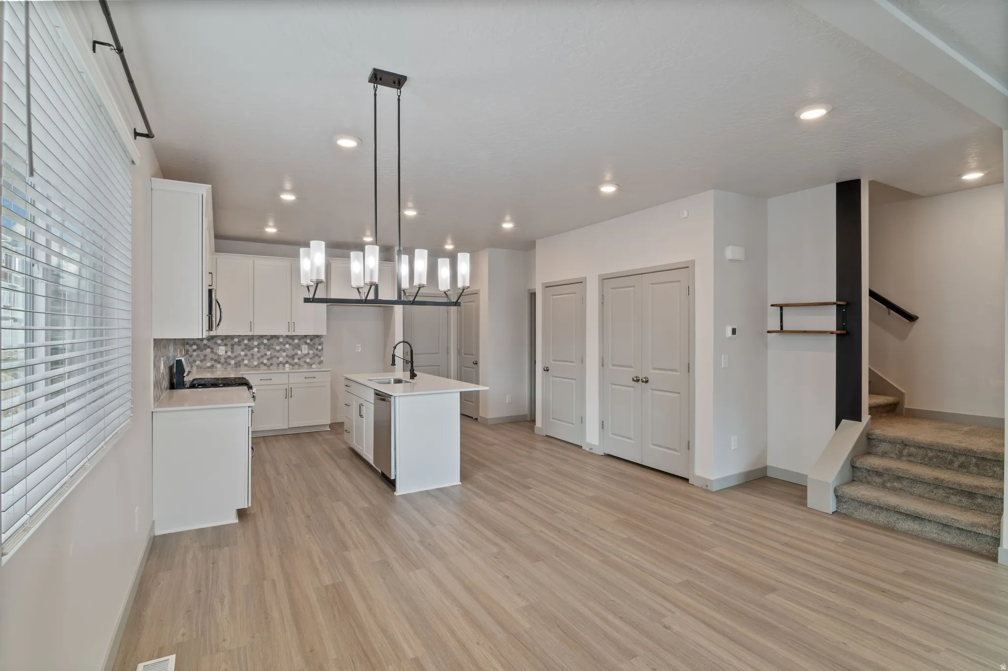 Open-concept living area featuring wood-finish flooring and recessed lighting