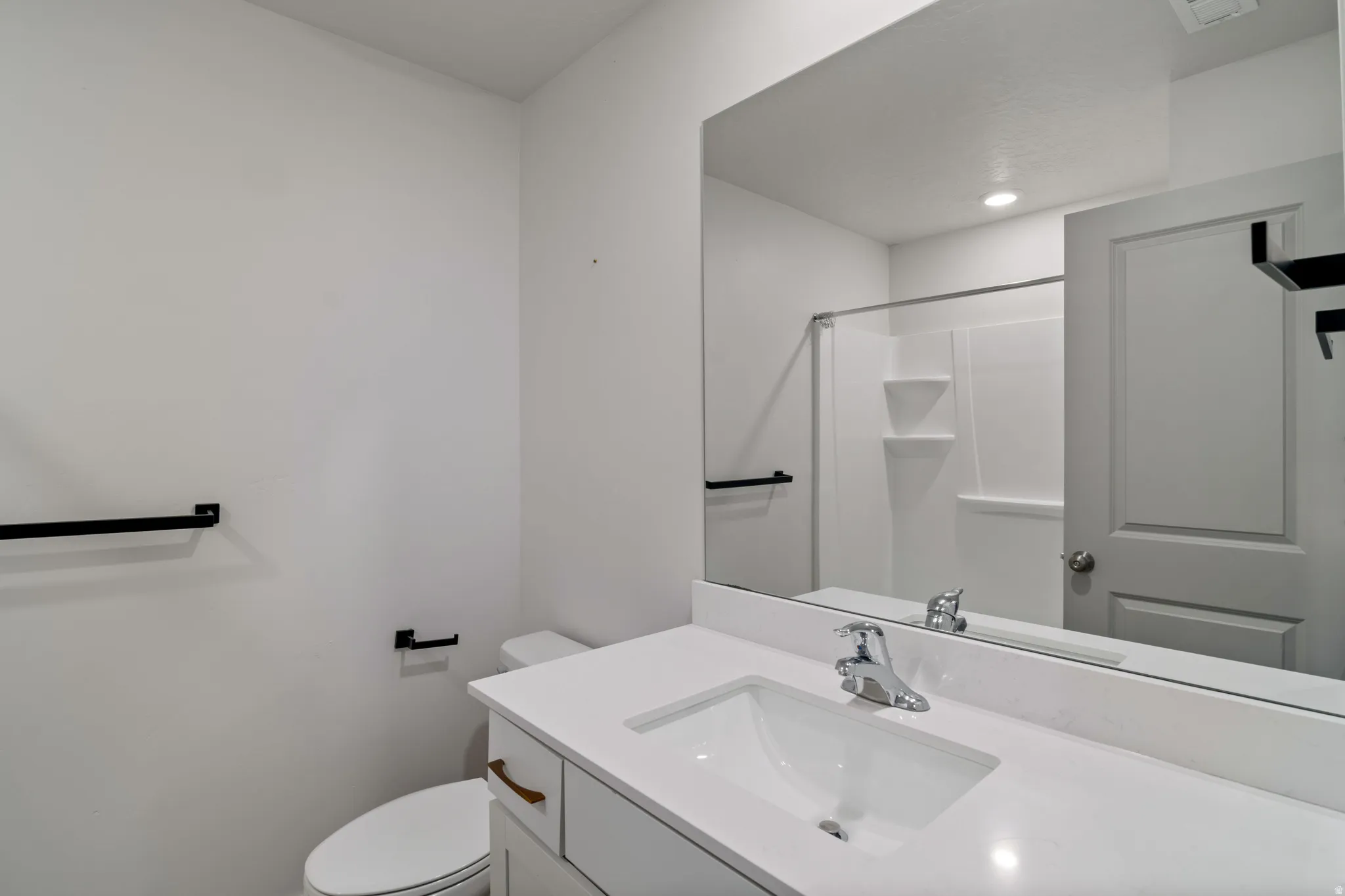 Full Bathroom vanity featuring a single basin sink, white countertop, and brushed nickel faucet