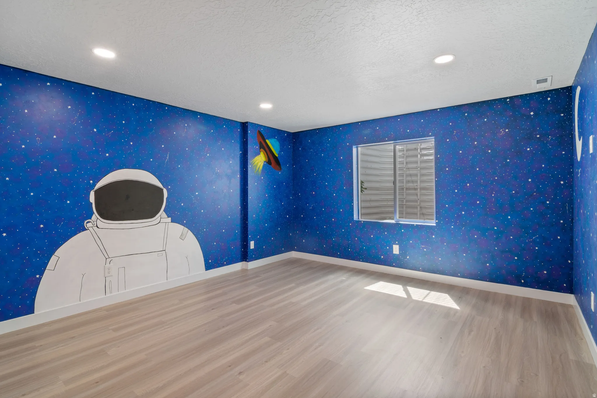 Large Bedroom featuring a vibrant space-themed mural, wood-finish flooring, a window, recessed ceiling lighting, and white baseboards