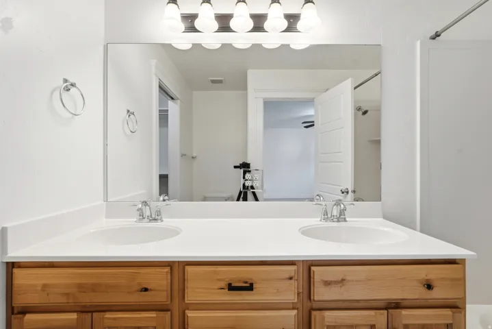 Double vanity featuring a white countertop with two undermount sinks and chrome fixtures