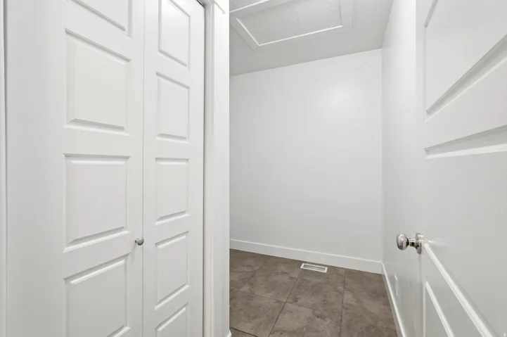 White interior space featuring bi-fold panel doors and a solid panel door with chrome hardware