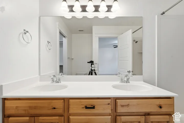 Double vanity featuring a white countertop with two undermount sinks and chrome fixtures