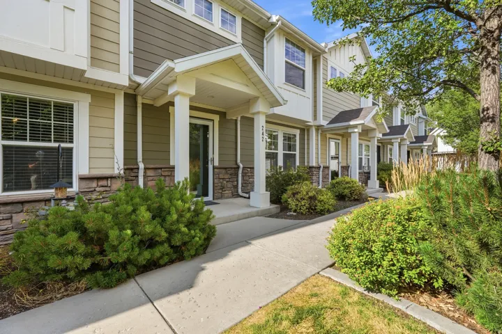 Townhome exterior featuring horizontal siding, stone veneer accents, and white trim