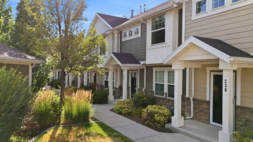 Townhome exterior featuring horizontal siding and stone veneer accents