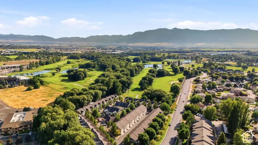 Aerial perspective showcasing residential properties bordering a manicured golf course with multiple water features