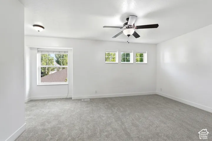 Spacious room featuring light gray carpeting and white walls