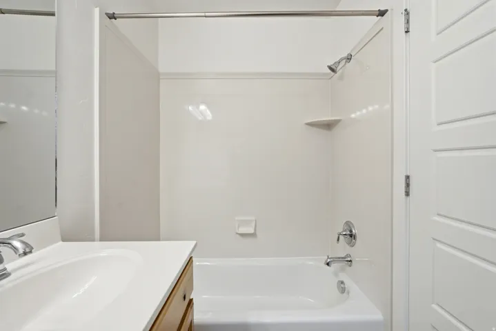 White bathtub and shower surround with an integrated corner shelf and soap dish