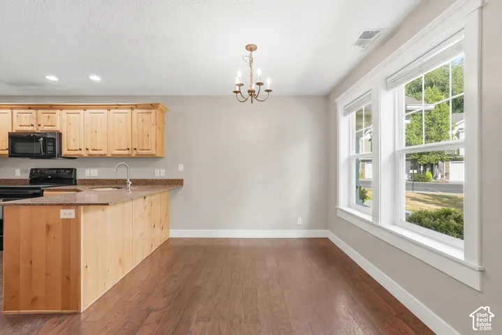 Open-concept kitchen and dining area featuring warm wood-finish flooring