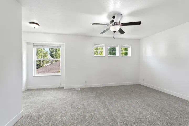 Spacious room featuring light gray carpeting and white walls