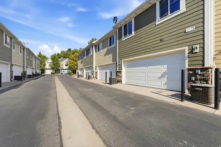 Property exterior featuring horizontal siding, white paneled garage door, and stone accents