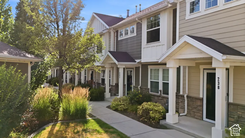 Townhome exterior featuring horizontal siding and stone veneer accents