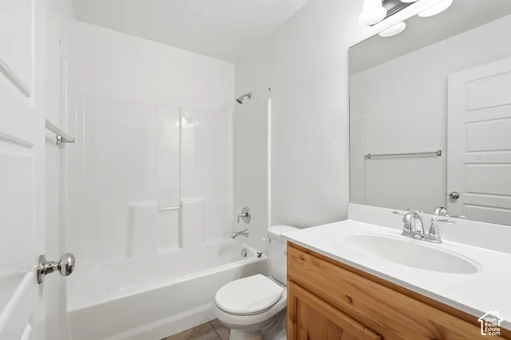 Bathroom featuring a wood-finish vanity with a white countertop, an oval undermount sink, and a chrome faucet
