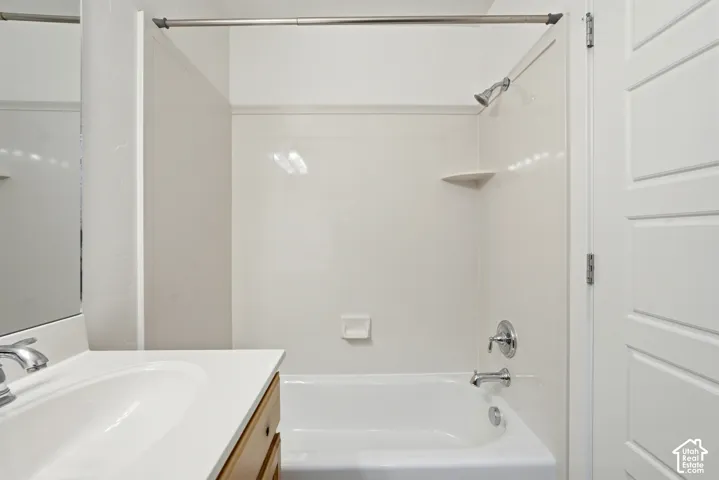 White bathtub and shower surround with an integrated corner shelf and soap dish