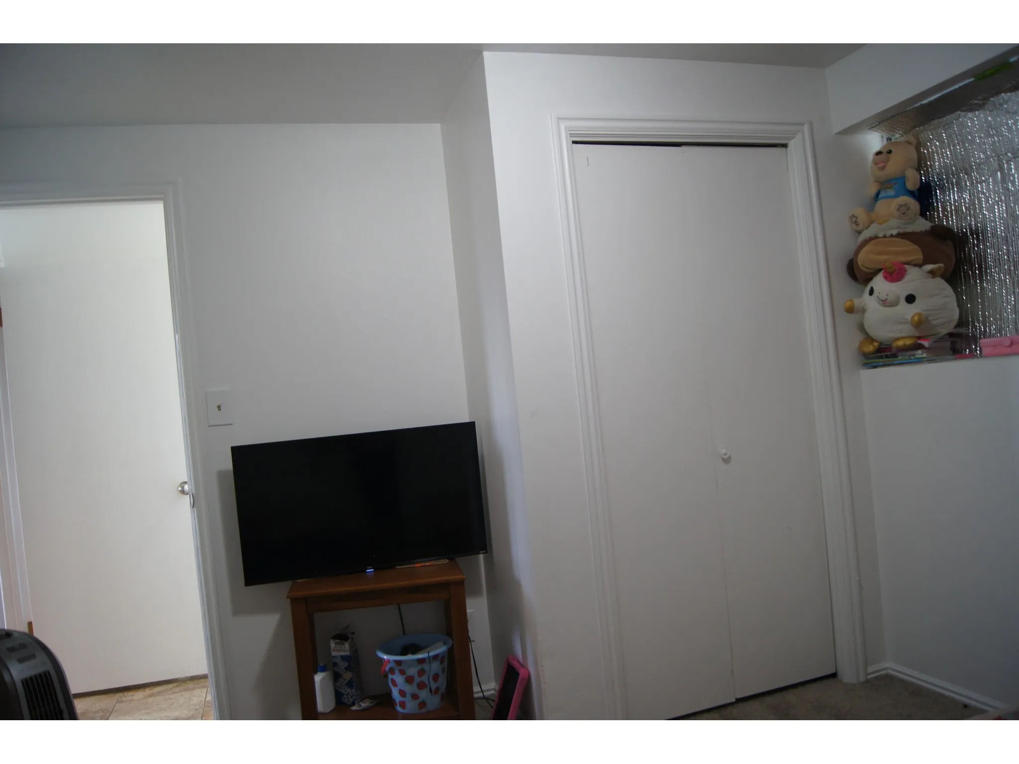 Bedroom 4 Interior room featuring white painted walls and trim, a bi-fold closet door, and a standard interior door