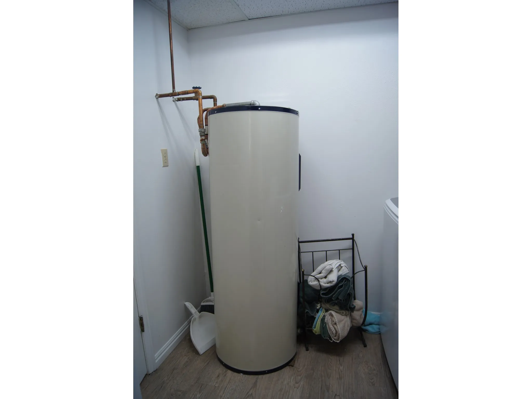 Built-in water heater with visible copper piping and wood-finish flooring