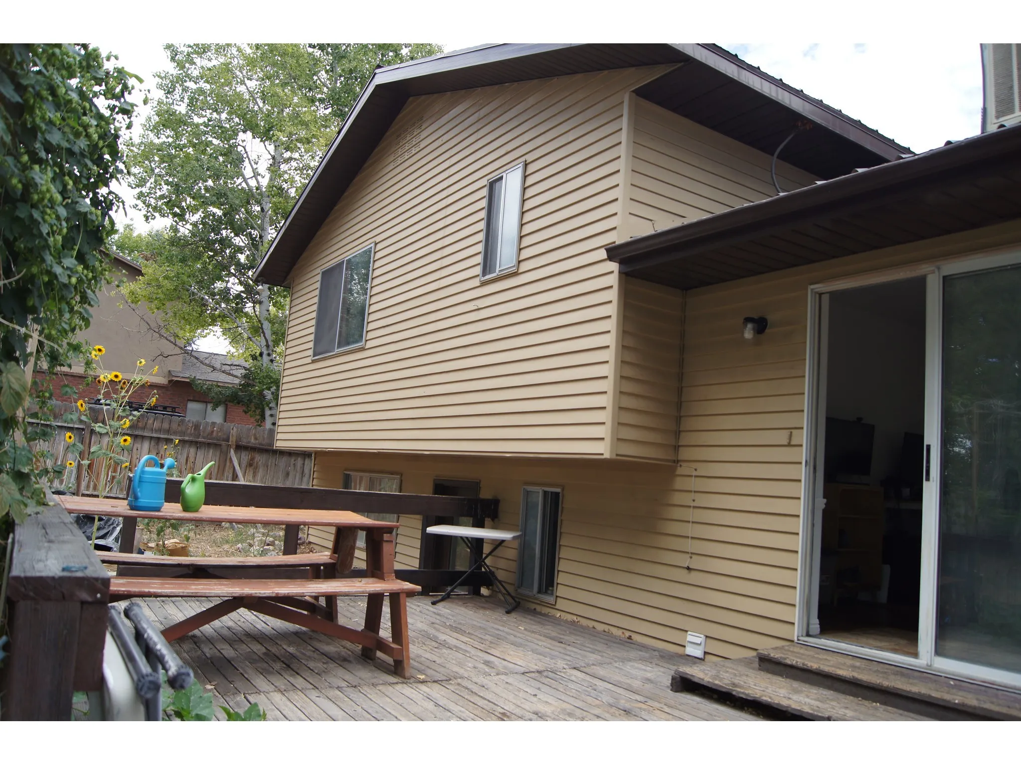 Expansive outdoor deck featuring wood flooring and a sliding glass door for interior access