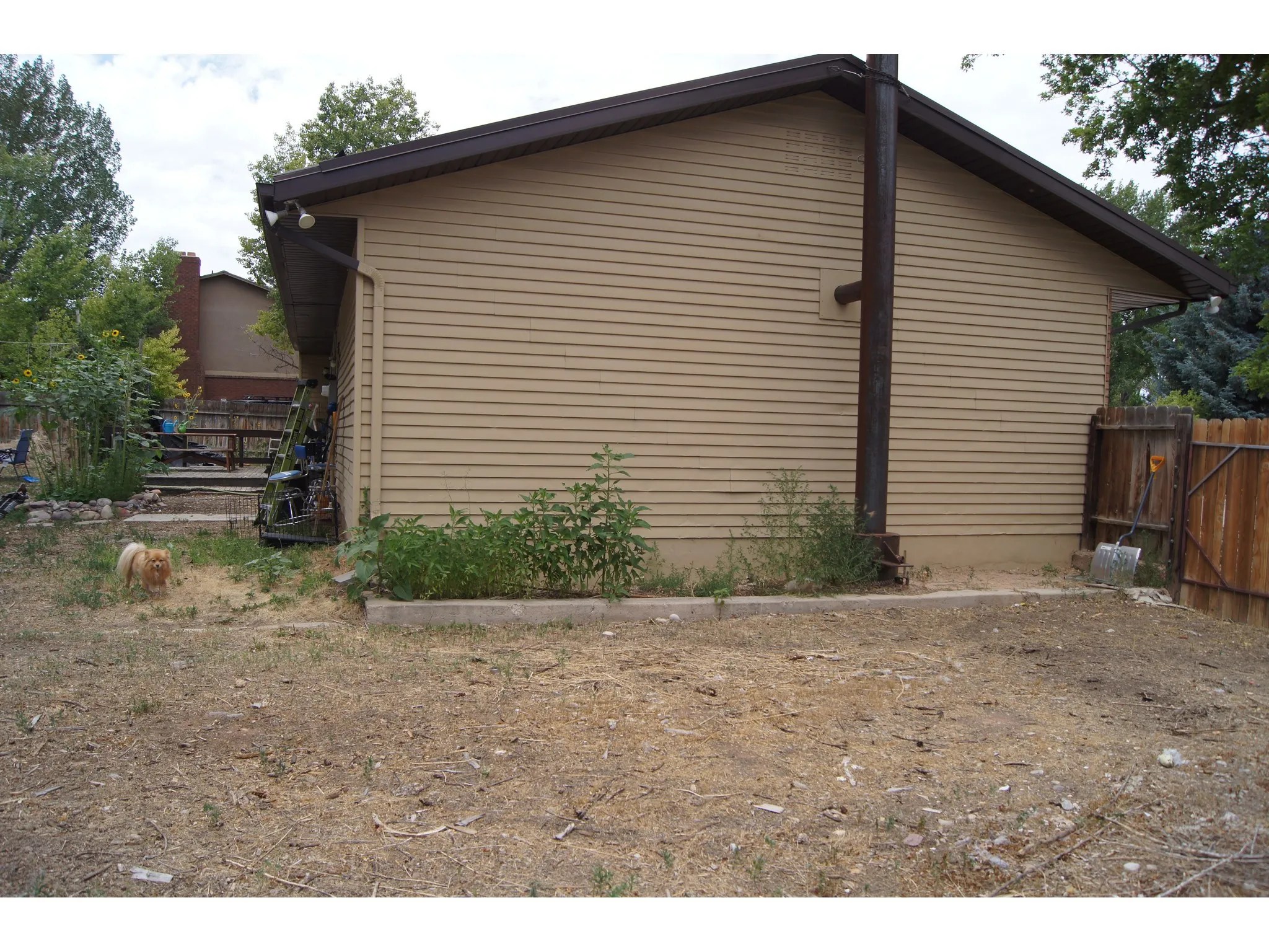 Exterior siding in a neutral tone with dark brown eaves and gutters