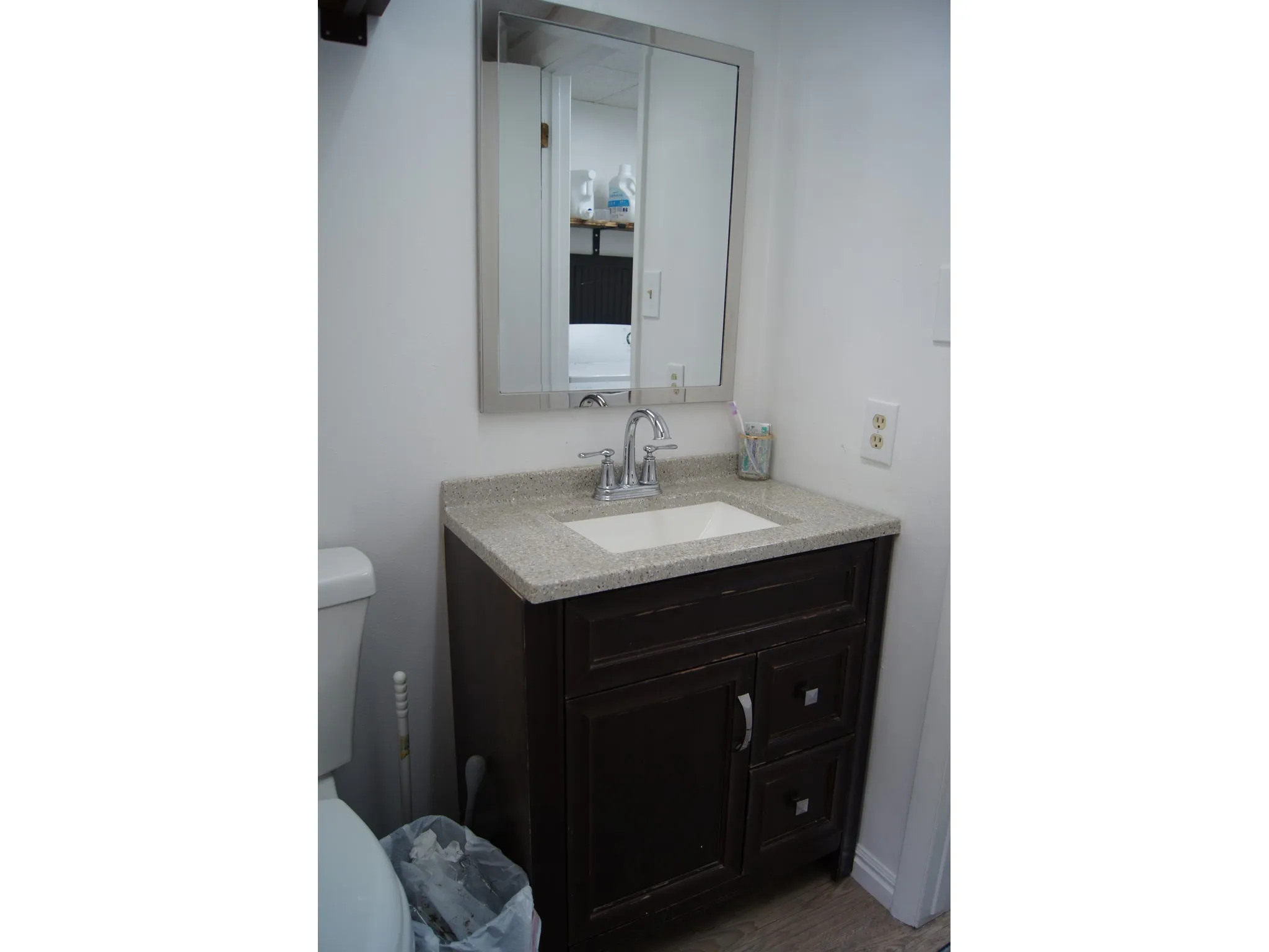 Vanity with a light-toned countertop, a rectangular undermount sink, and a chrome faucet