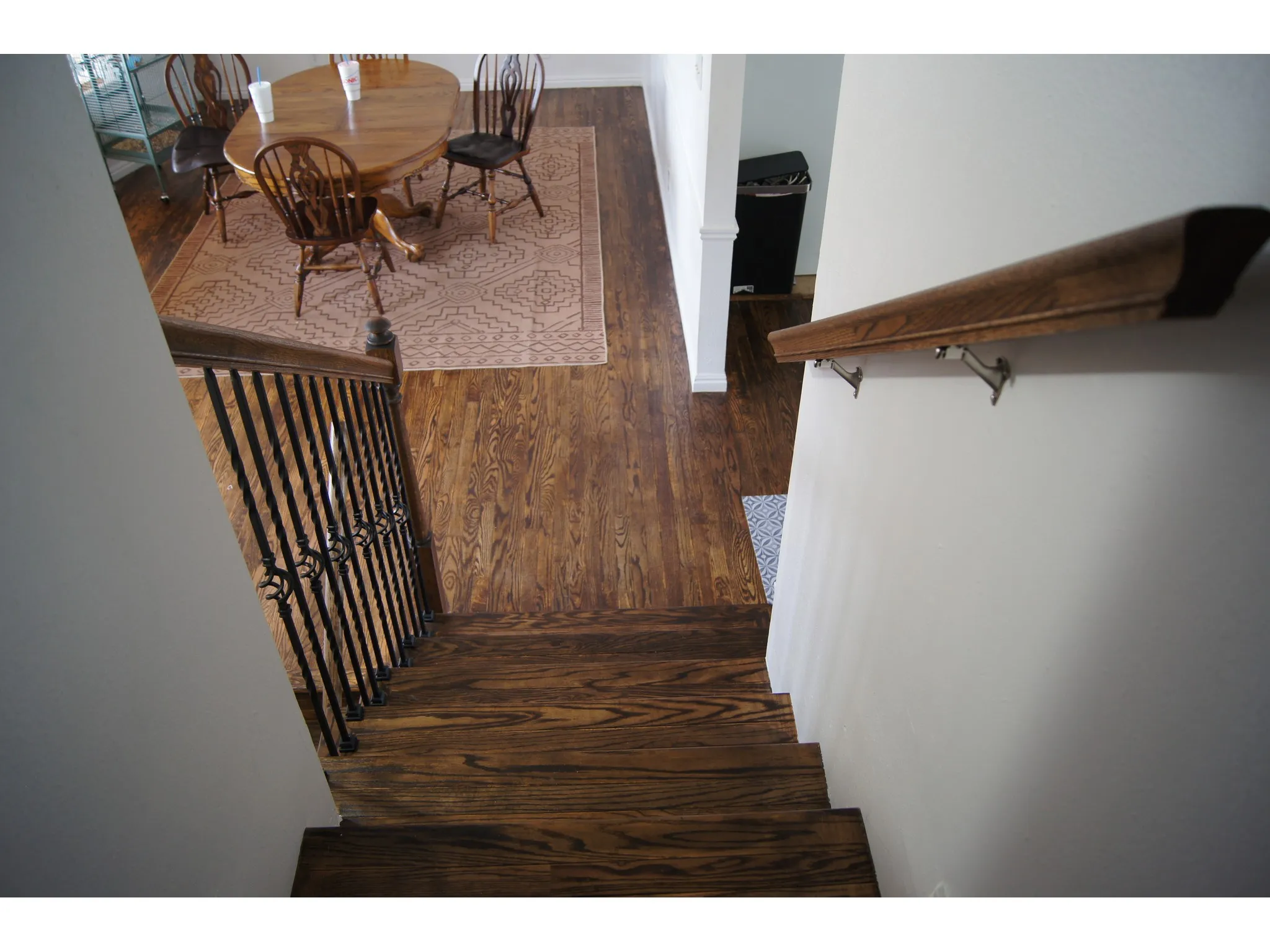 Hardwood staircase featuring dark wood treads and risers, complemented by a black wrought iron baluster system and a matching wood handrail