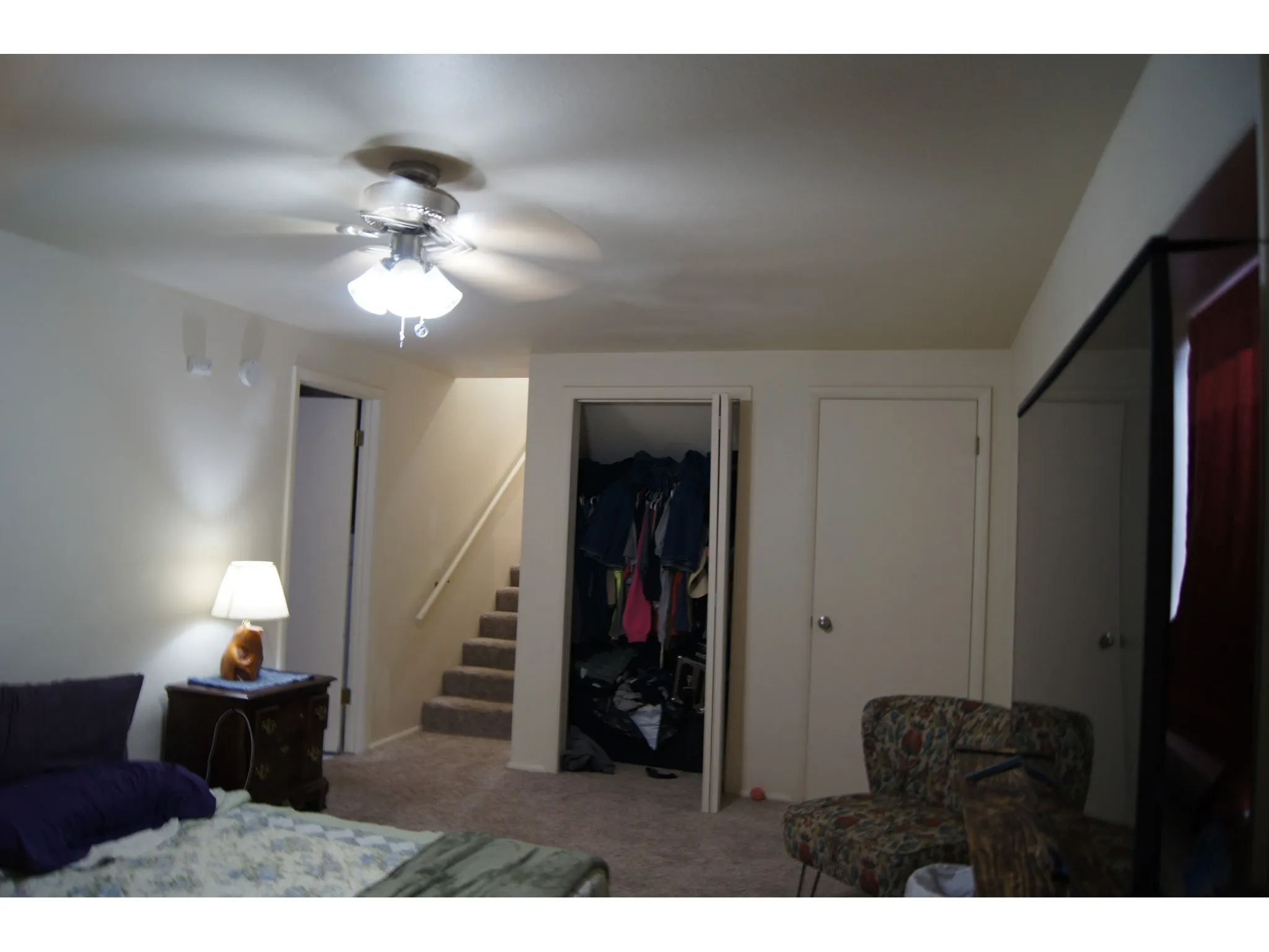 Bedroom 5 Carpeted room featuring a ceiling fan with light fixture, light-colored walls, and a built-in closet with double doors