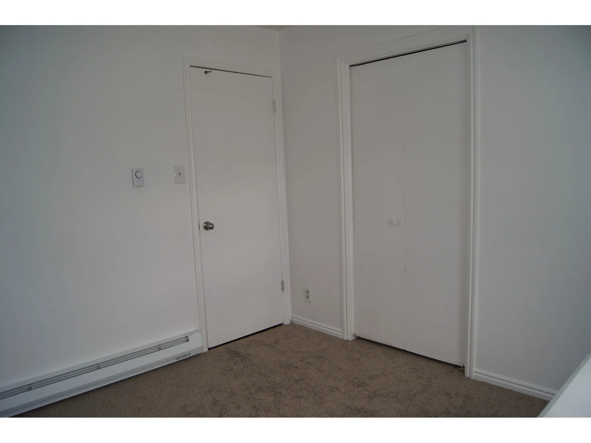Bedroom 1 White wall finish featuring a single door, bi-fold closet doors, and carpet flooring