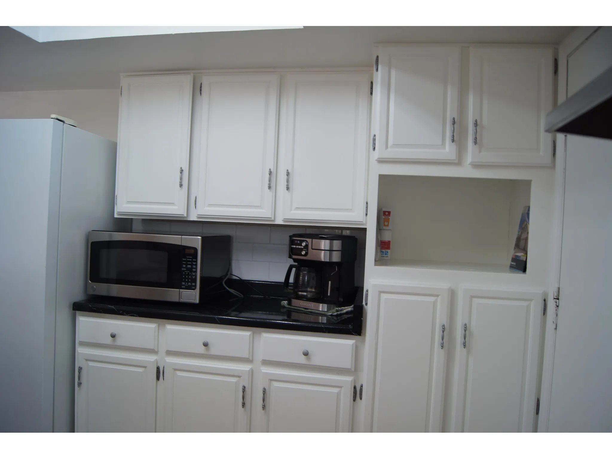 White cabinetry with dark countertops