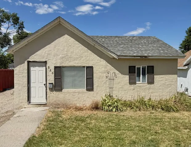 Stucco exterior with a peaked roofline and asphalt shingles
