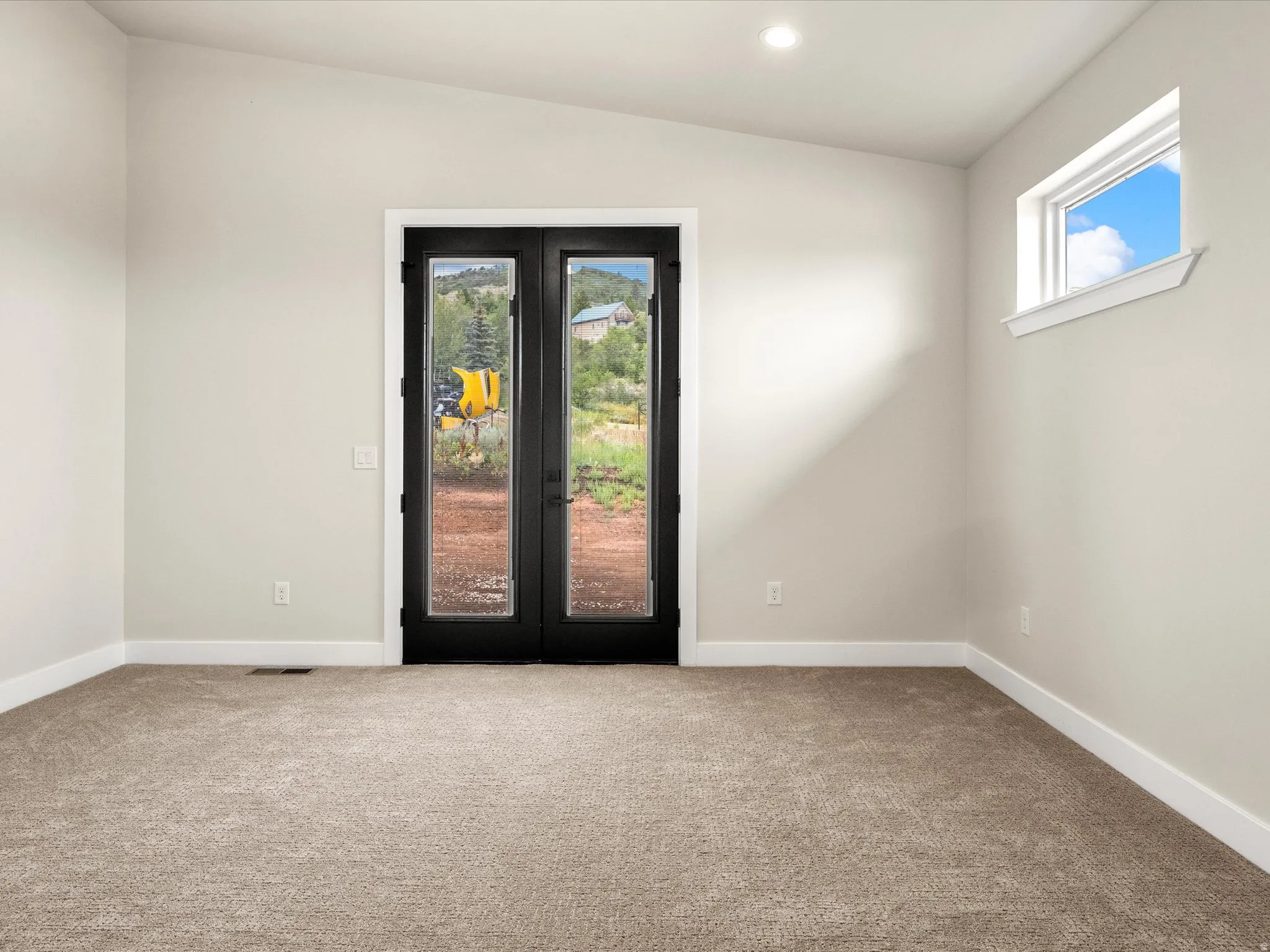 Room featuring a vaulted ceiling with recessed lighting, light beige carpeting, white baseboards, and neutral wall paint