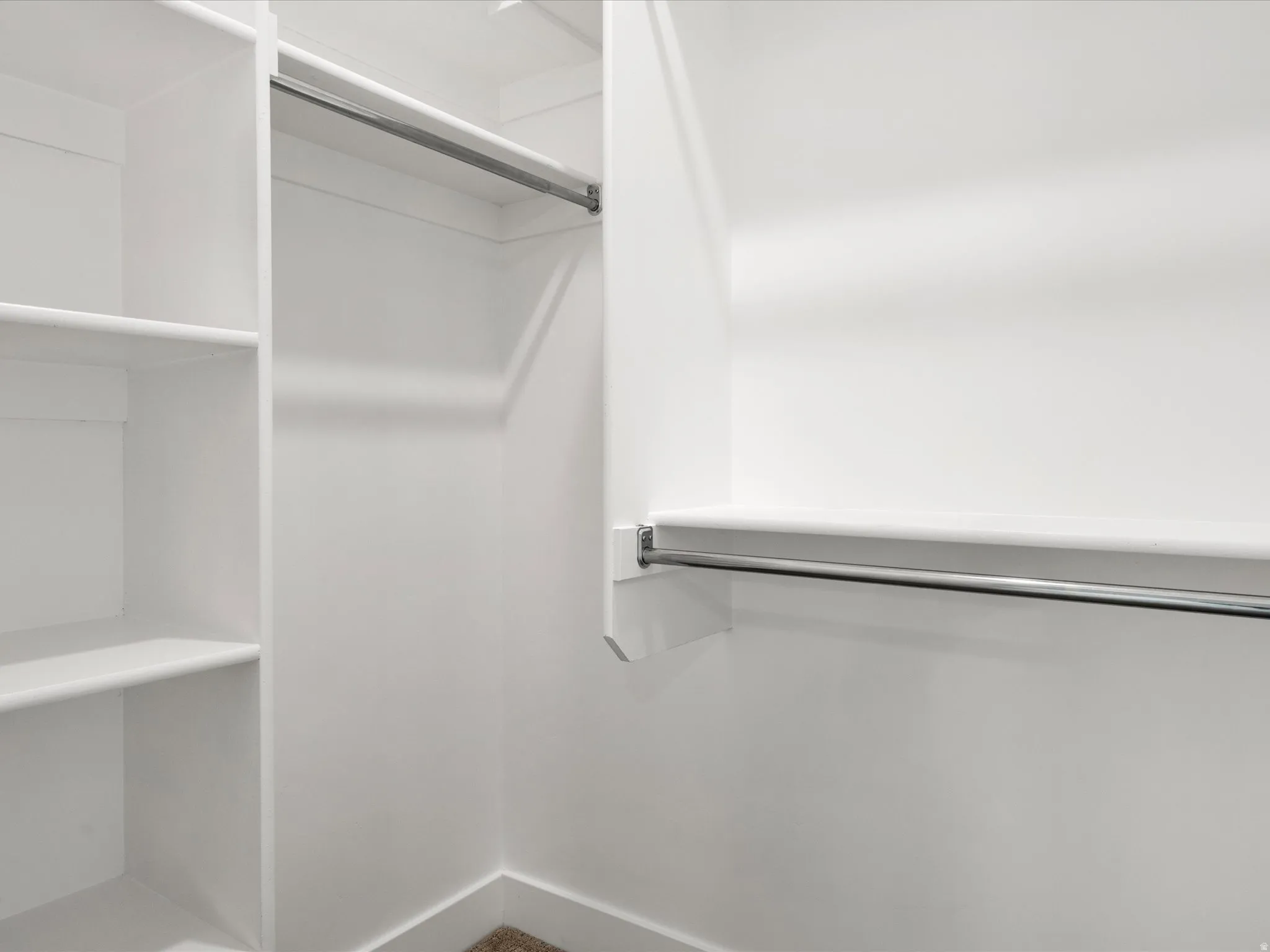 Integrated closet system featuring multiple shelves and chrome hanging rods