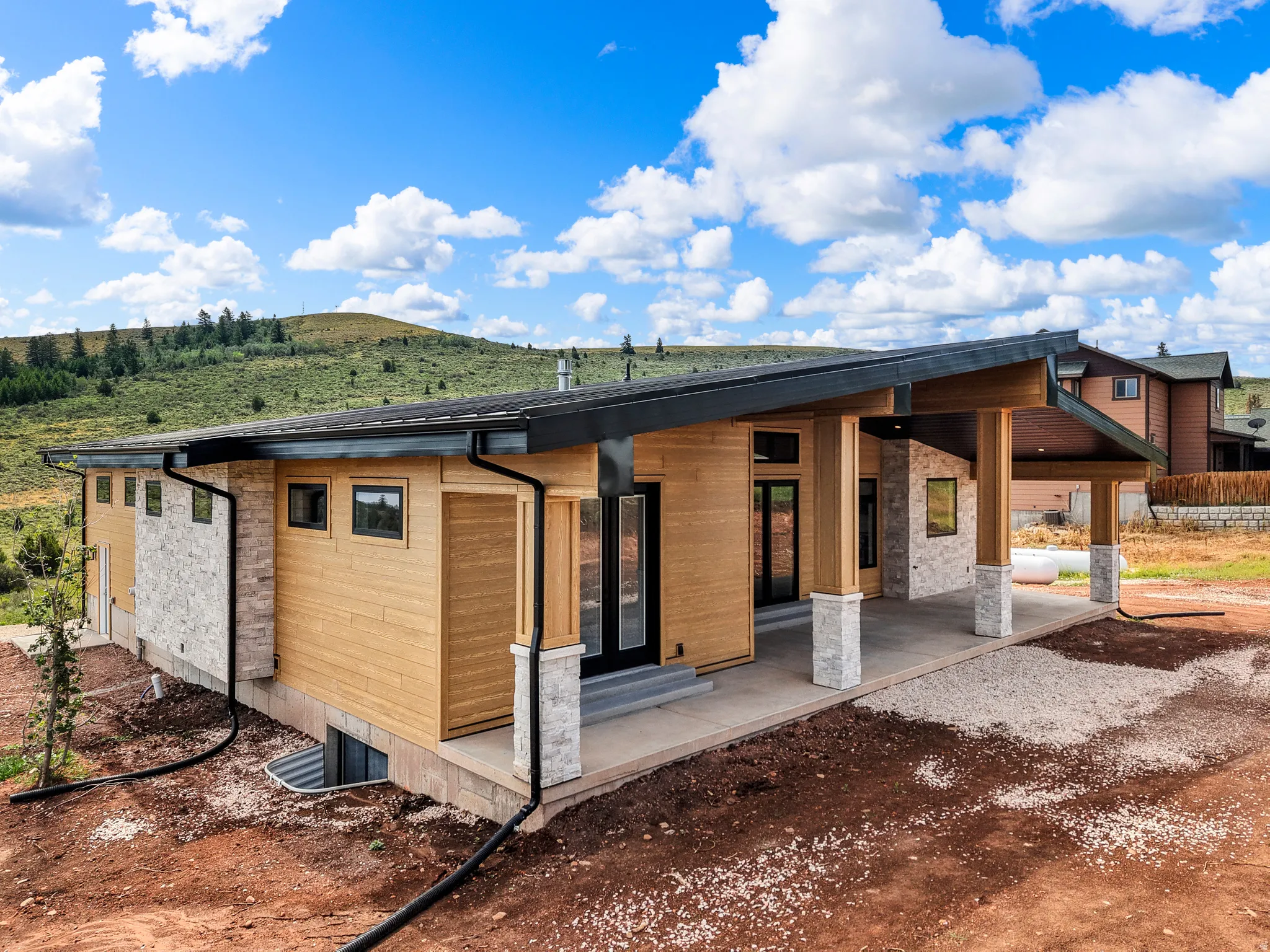 Modern exterior featuring natural wood siding and stone accents