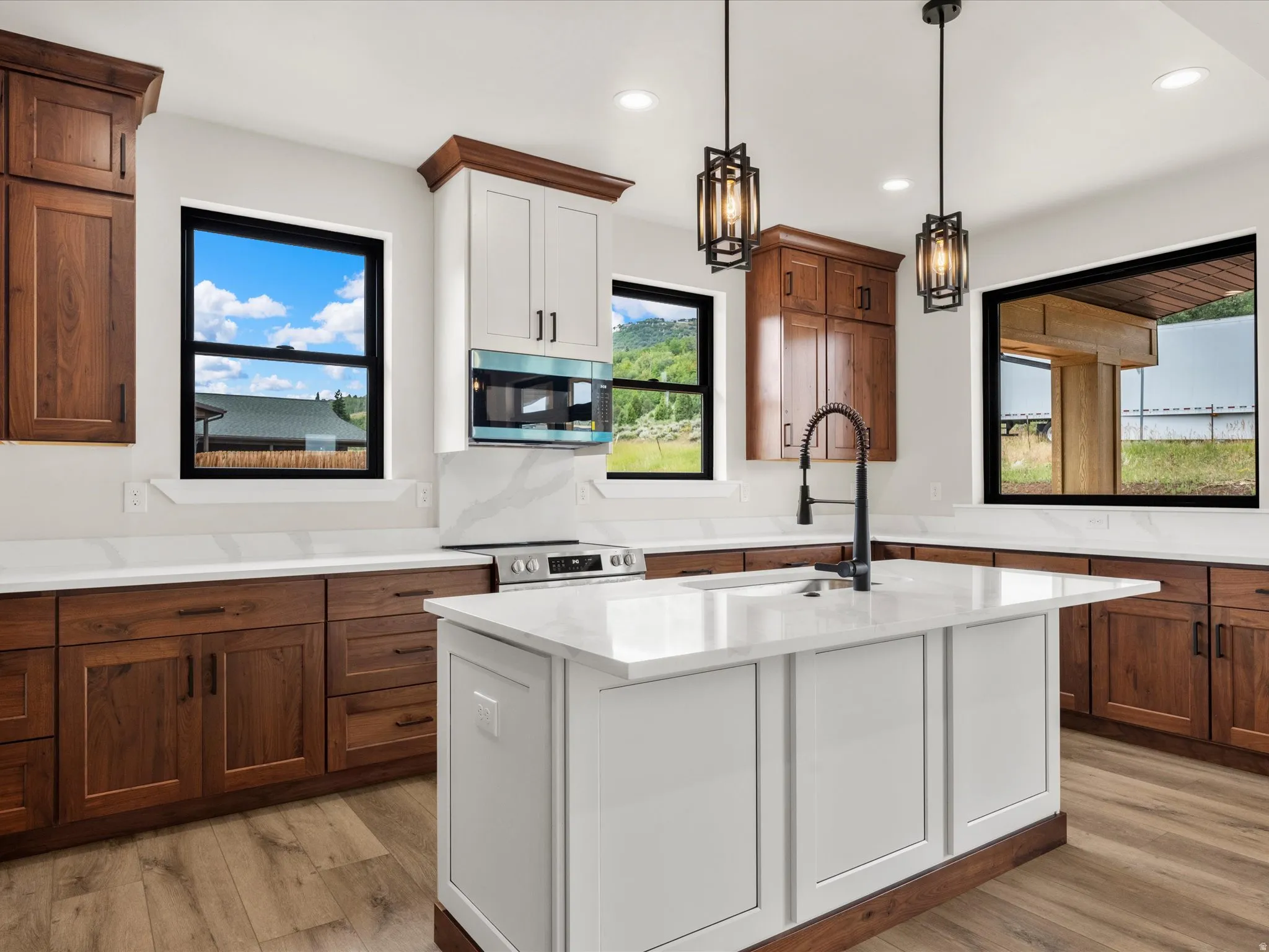 Modern kitchen featuring a central island with a white countertop and panel cabinetry