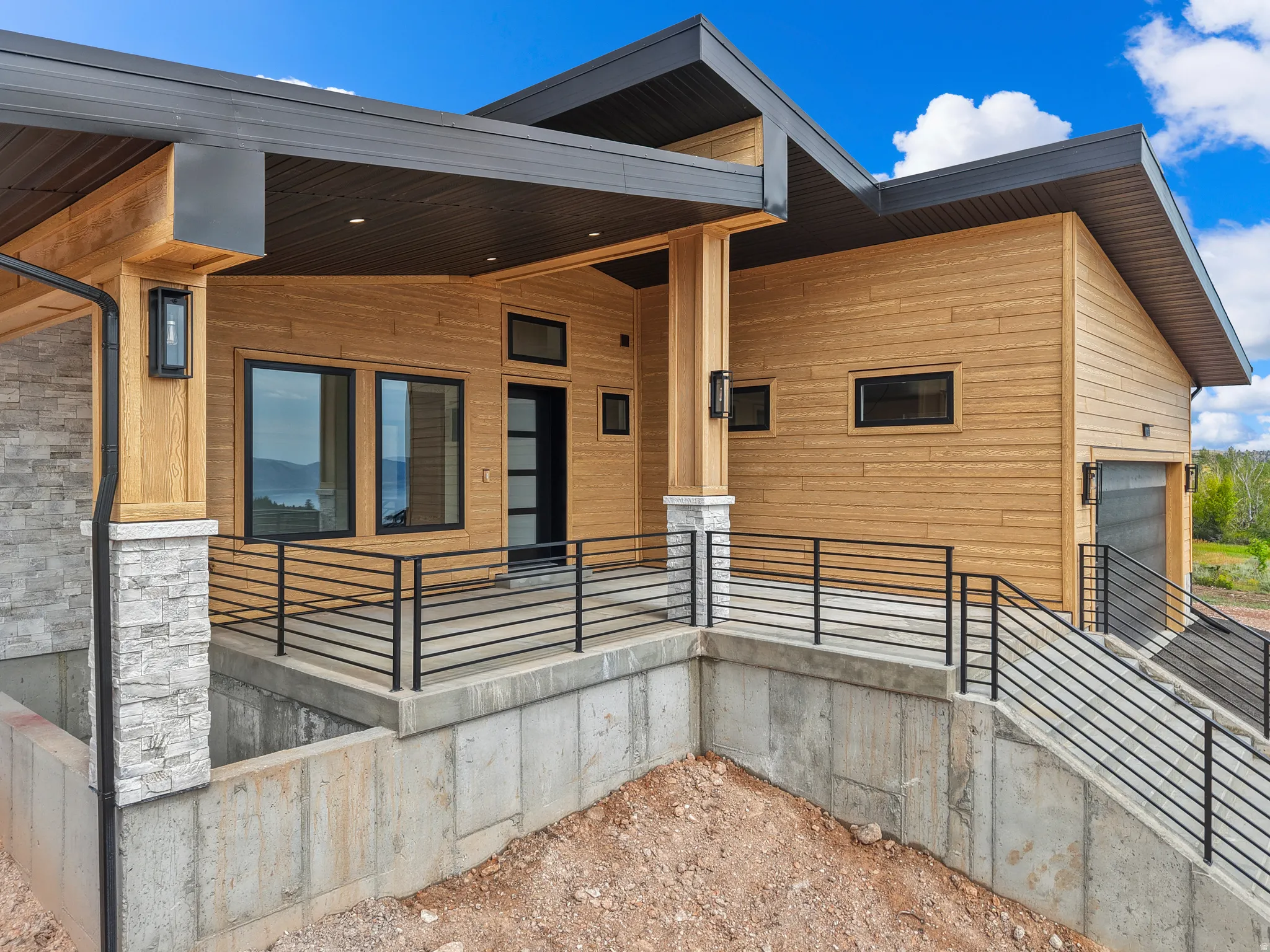 Modern exterior showcasing light wood-finish siding and dark trim accents