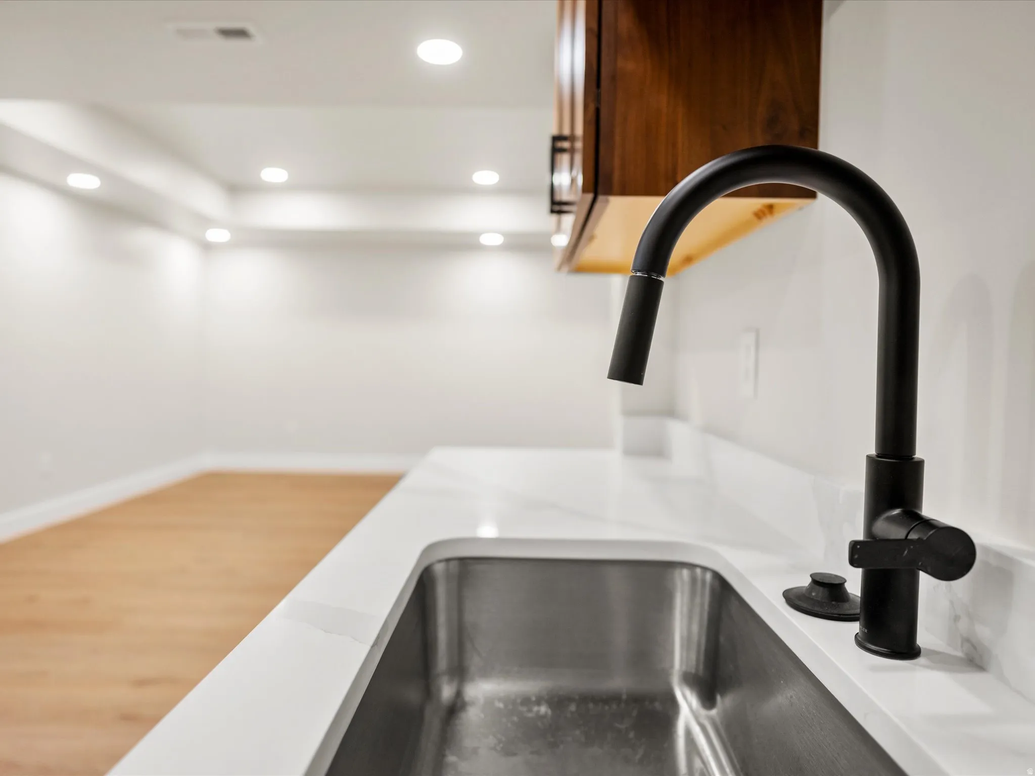 Stainless steel undermount sink with a matte black gooseneck faucet