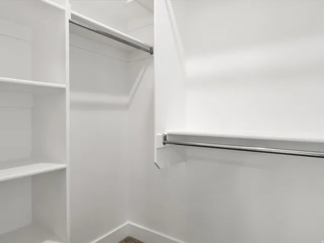 Integrated closet system featuring multiple shelves and chrome hanging rods