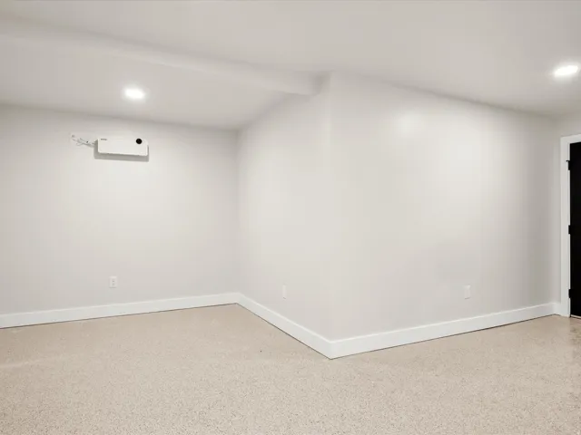 Carpeted room featuring white walls, recessed lighting, and white baseboards