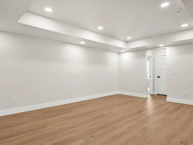 Spacious interior featuring wood-finish flooring, white walls, and bright recessed lighting