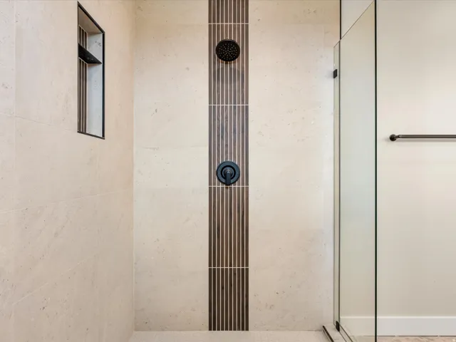 Shower enclosure featuring large format stone-finish wall tile