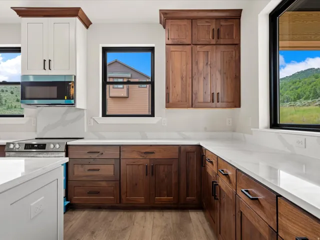 Kitchen featuring a stainless steel range, white countertops, and wood-finish flooring